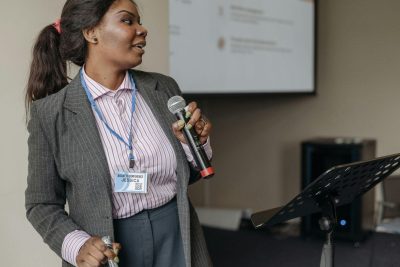Woman holding a microphone giving a presentation
